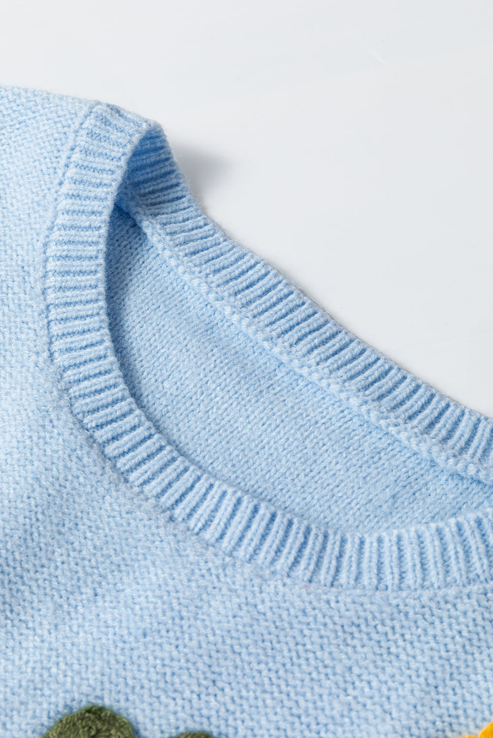 Light blue knitted sweater with ribbed edges and floral pattern