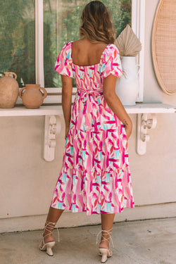 Smocked pink dress with ruffles and brush kick print