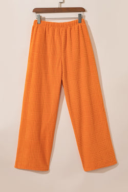 Camiseta con textura naranja y pantalones anchos