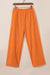 Camiseta con textura naranja y pantalones anchos