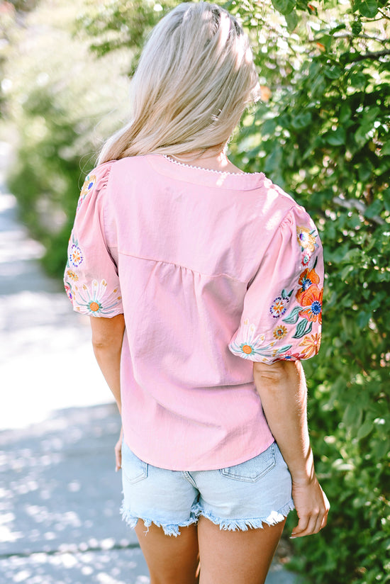 Blusa rosa con flores bordadas y mangas hinchadas, cuello dividido