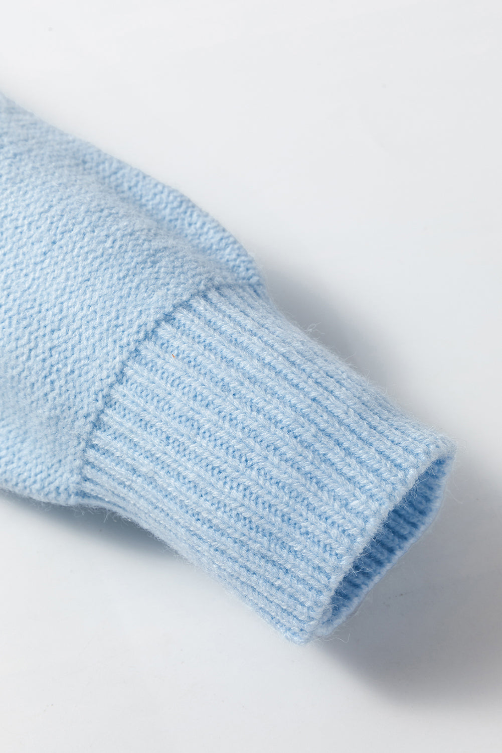 Light blue knitted sweater with ribbed edges and floral pattern