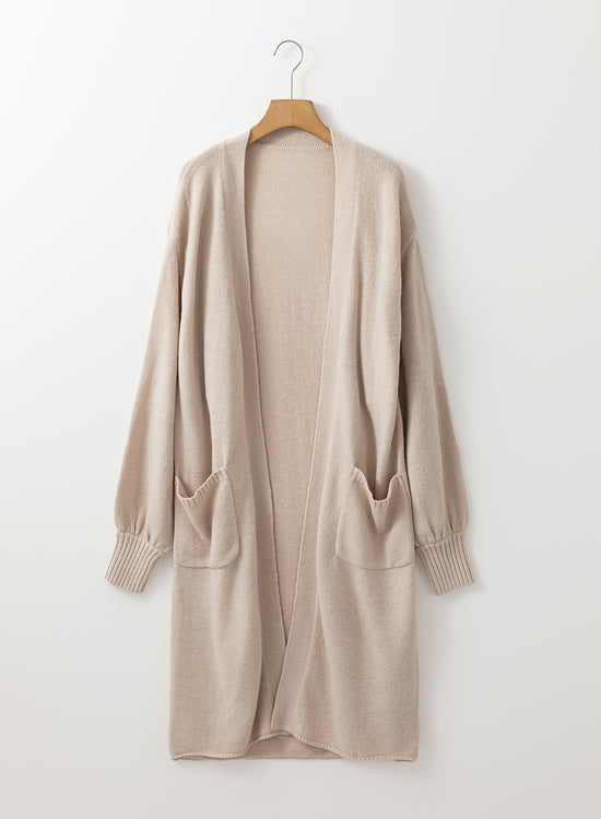 Cardigan long tricoté beige avec poches latérales ouvertes sur le devant