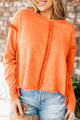 Orange raw edge sweatshirt with exposed seams, top and bottom