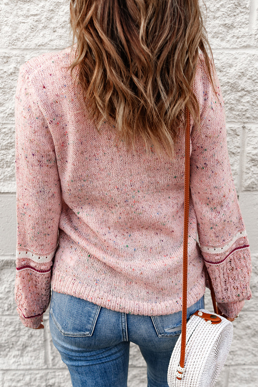 Pink sweater with patterned sleeves and pilled details