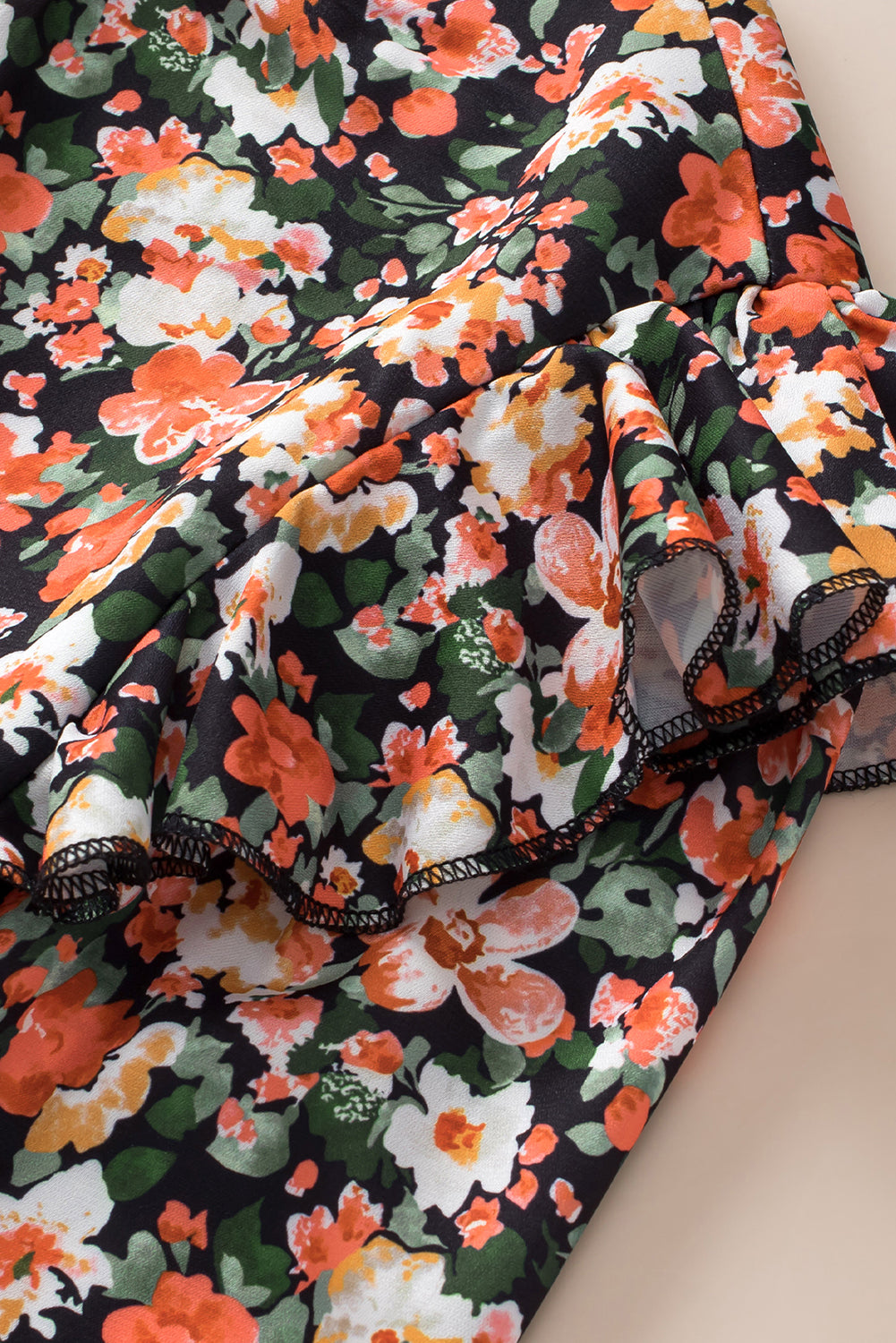 Blouse florale orange à volants et poignets froncés