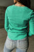 Alto Henley en tejido verde en relieve con un escote limitado