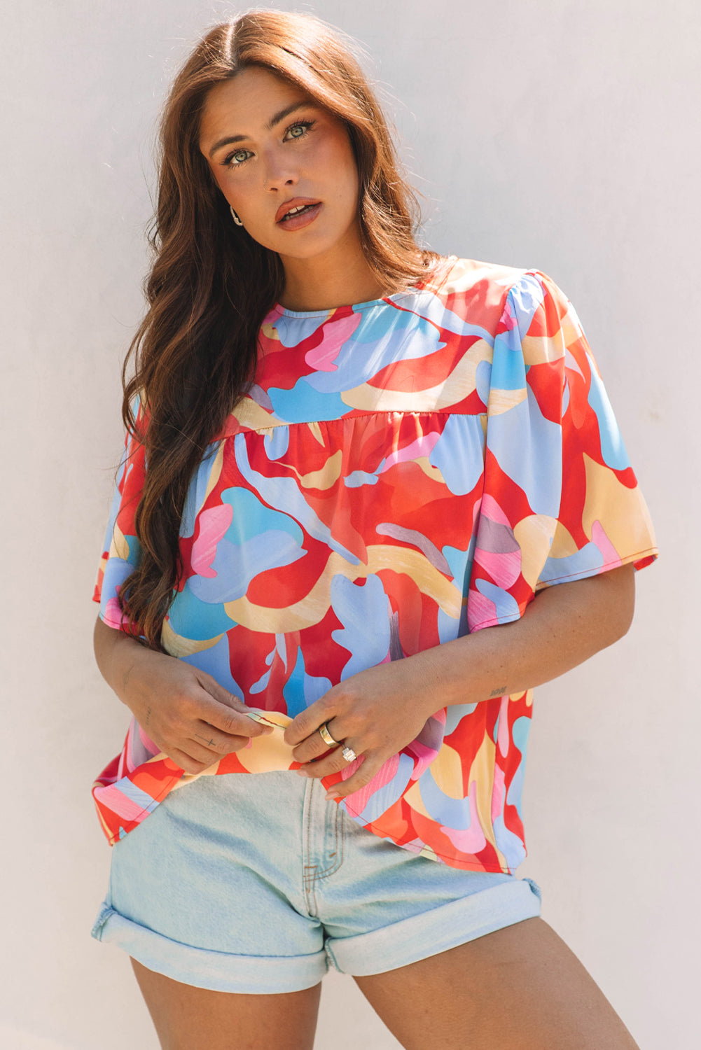 Blusa multicolor con cuello y mangas anchas con un patrón abstracto