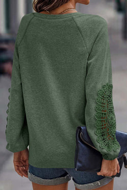 Green top with raglan sleeves and crochet lace patch