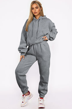 Juego de ropa deportiva gris lisa con sudadera con capucha y pantalones para trotar con hombros que caen