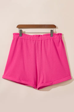 Large pink textured shorts with rolled edges and ruffles, elastic waist