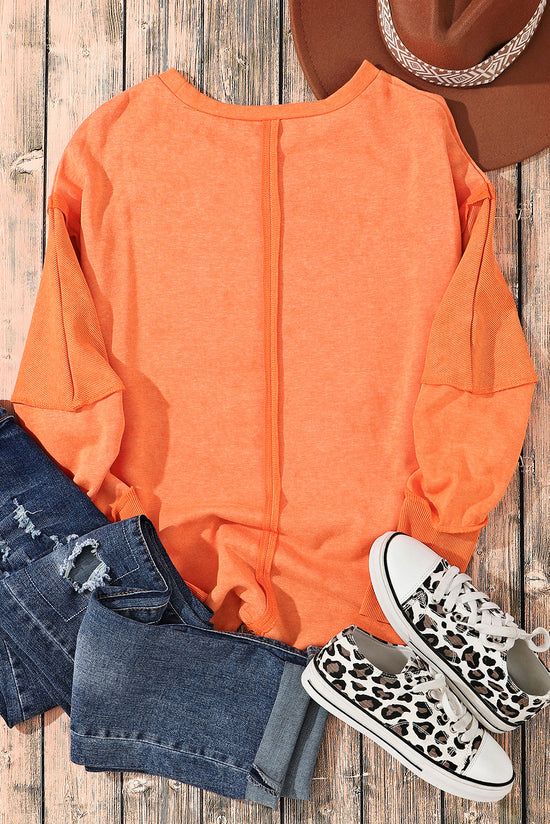 Orange raw edge sweatshirt with exposed seams, top and bottom