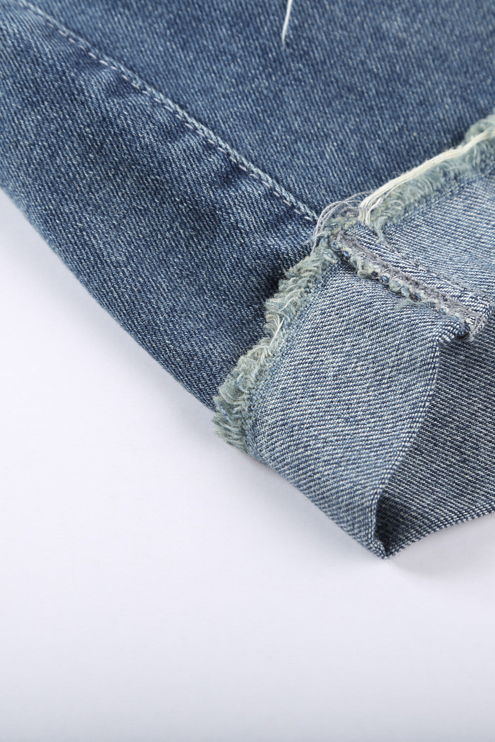 Pantaloncini di denim blu arrotolato strappato in difficoltà