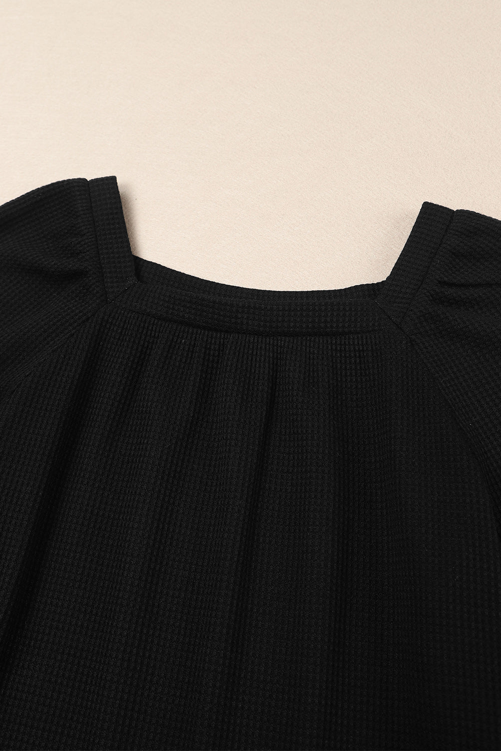 Black waffle knit top with puff sleeves and scoop neck