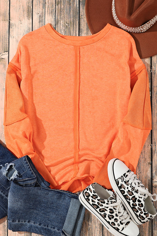 Orange raw edge sweatshirt with exposed seams, top and bottom