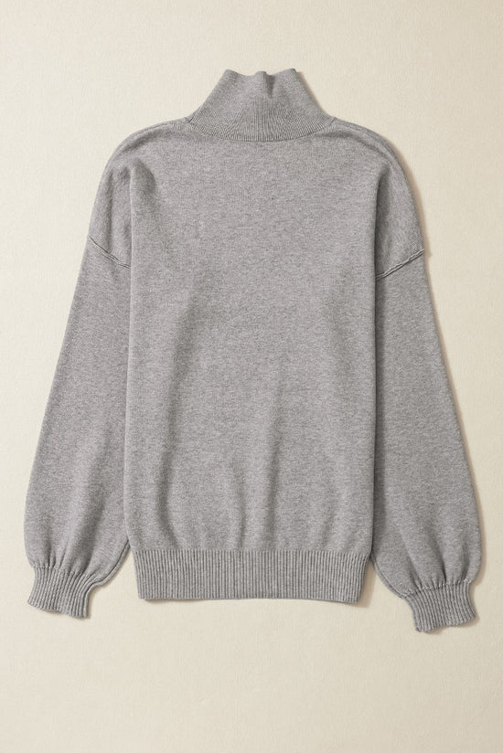 Pull en tricot gris à col roulé, épaules tombantes et manches bulles