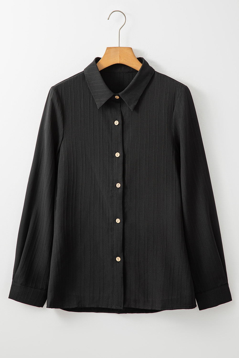 Chemise noire à col rabattu et boutonnée texturée de couleur unie