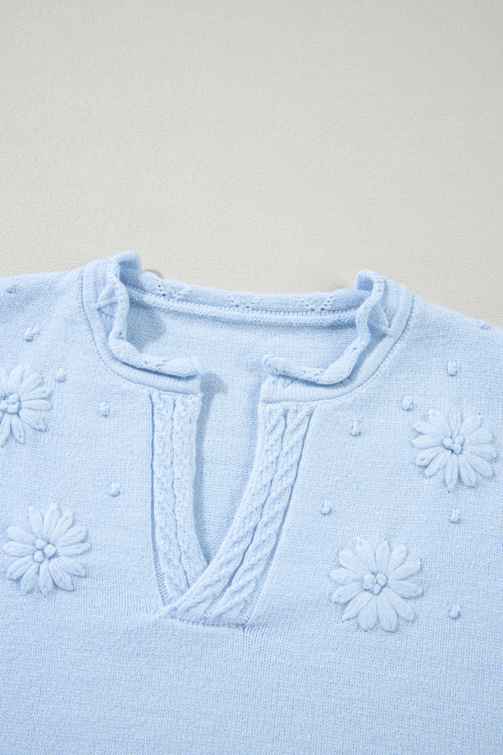 Pull tricoté à col cranté et détail de fleurs *