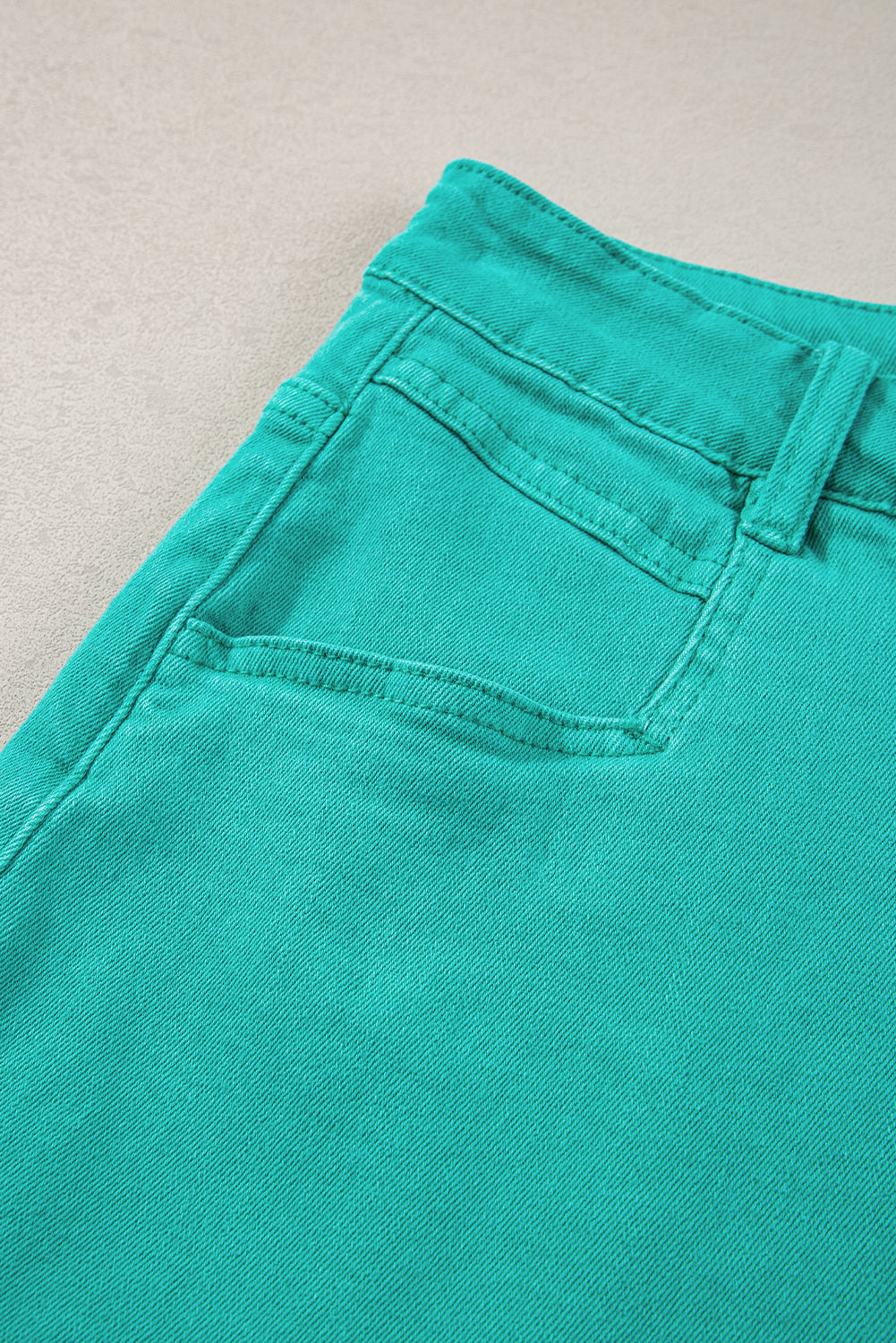 Mid-rise denim shorts with frayed edges in turquoise