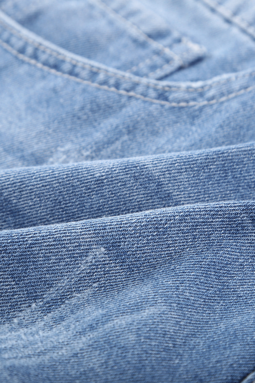 Pantaloncini di denim blu arrotolato strappato in difficoltà