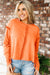 Orange raw edge sweatshirt with exposed seams, top and bottom