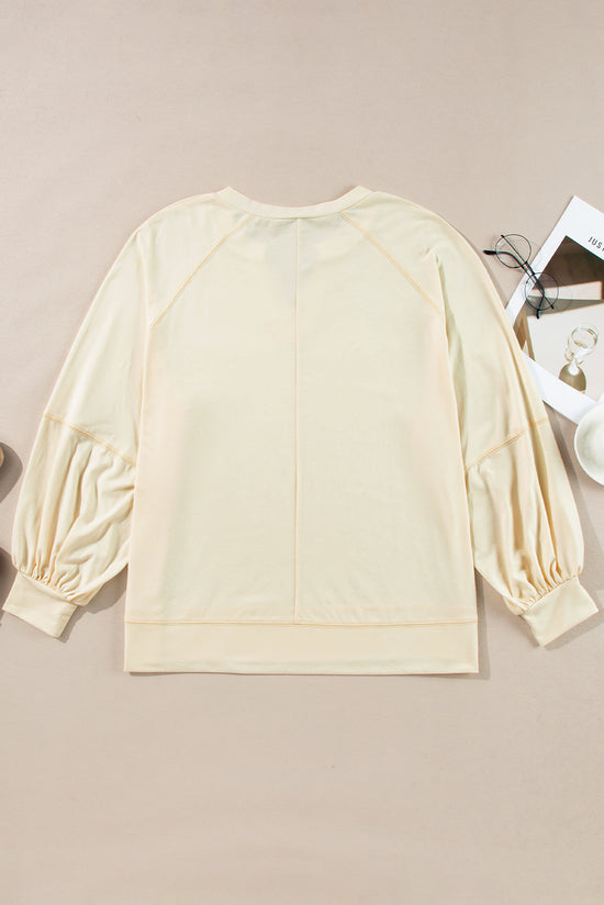 Apricot long sleeve top with notched neckline and exposed seams