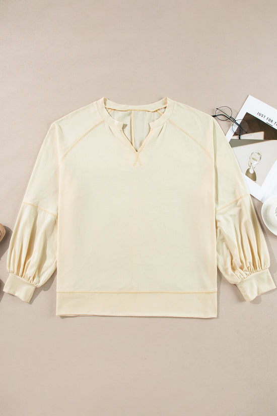 Apricot long sleeve top with notched neckline and exposed seams