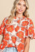 Blusa de manga suelta naranja y cuello volador y patrón floral