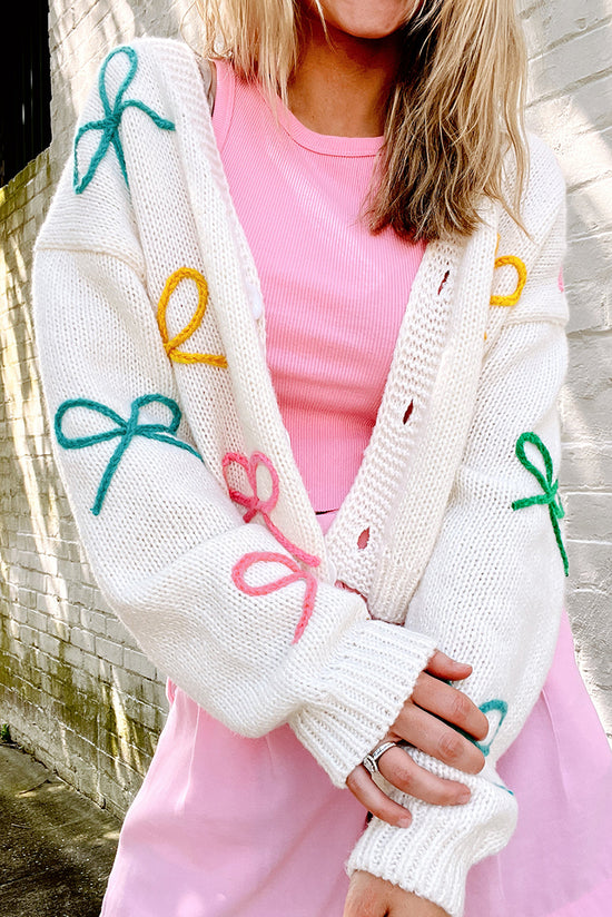 Cardigan boutonné en tricot blanc à épaules tombantes et nœud papillon