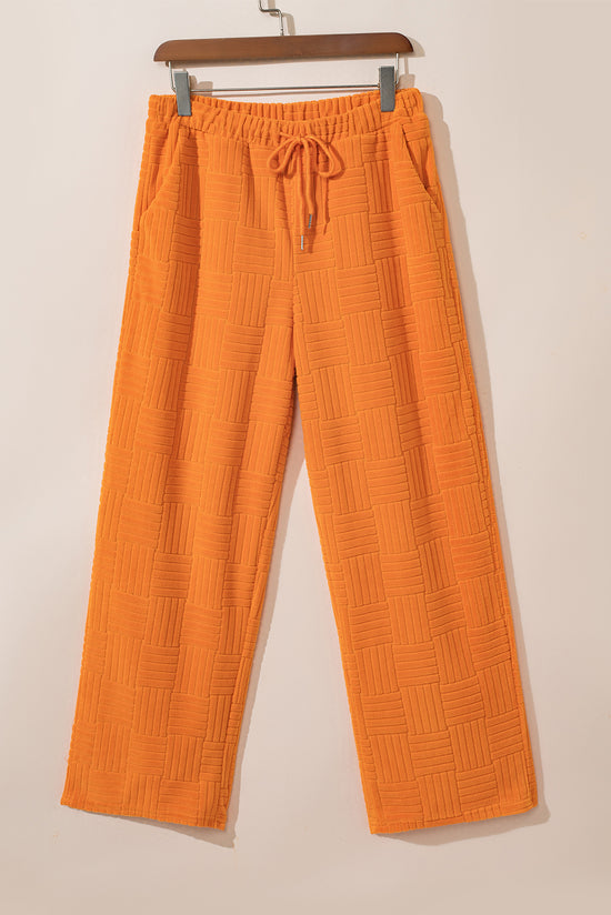 Camiseta con textura naranja y pantalones anchos