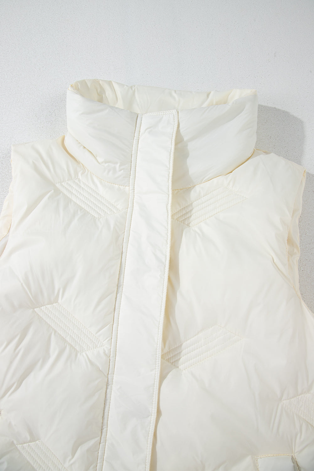 White quilted jacket with high collar and zipper