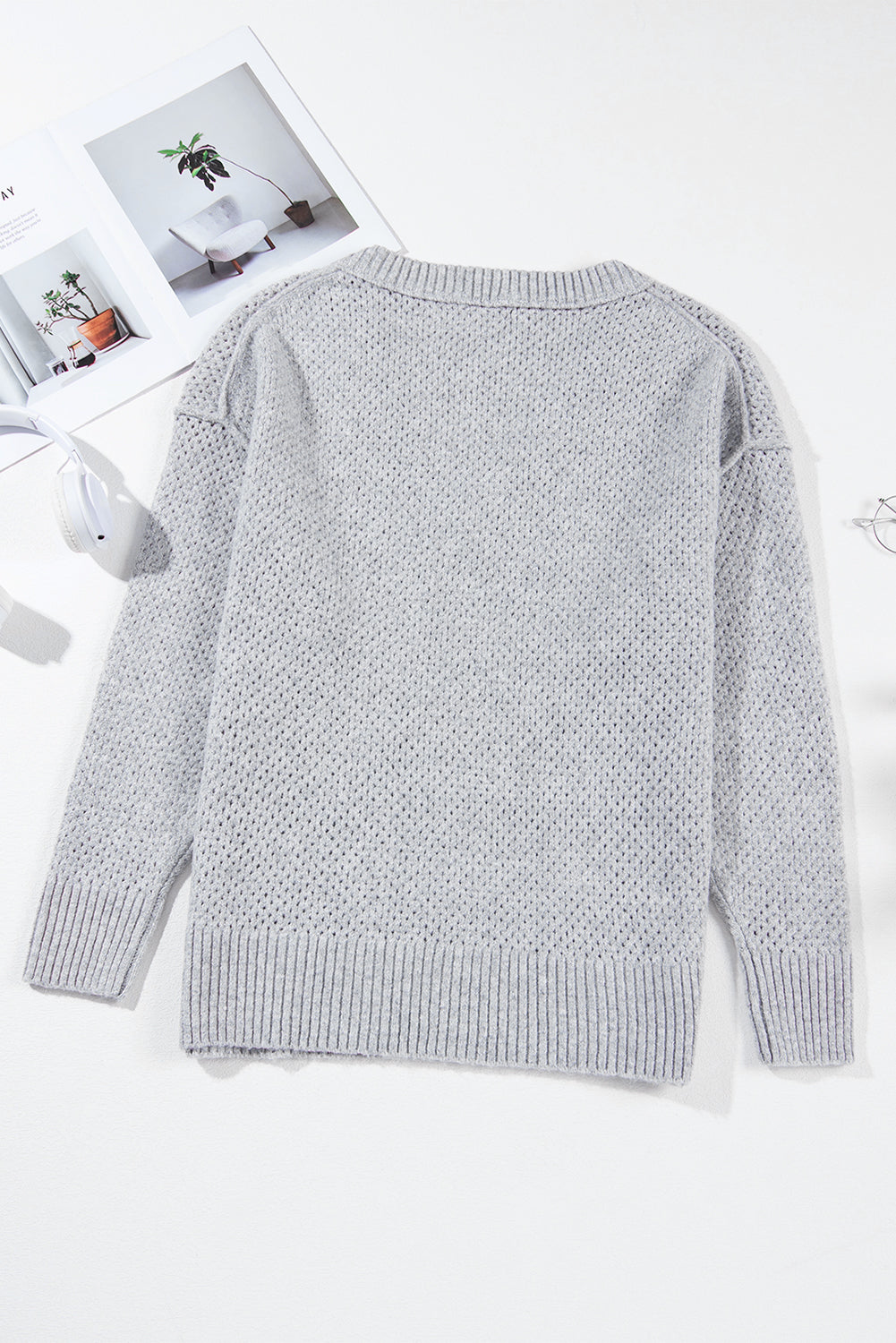 Pull ample gris clair à col en V et épaules tombantes avec œillets