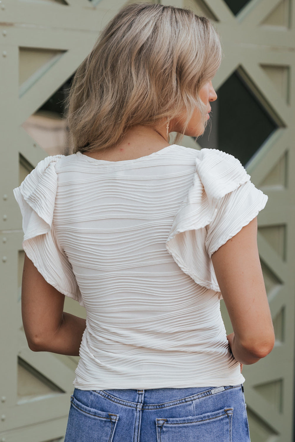 Haut blanc texturé ondulé à manches à volants