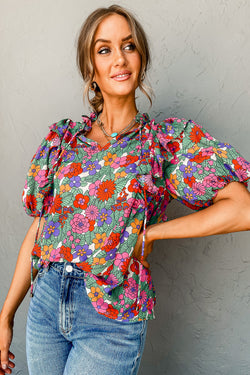 Red blouse with puffy sleeves and ruffles with split collar and floral tie