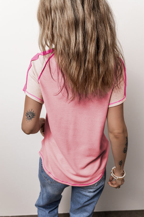 Camiseta rosa con cuello en V y costuras expuestas