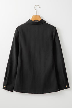 Black shirt with folded collar and textured buttonée of a plain color