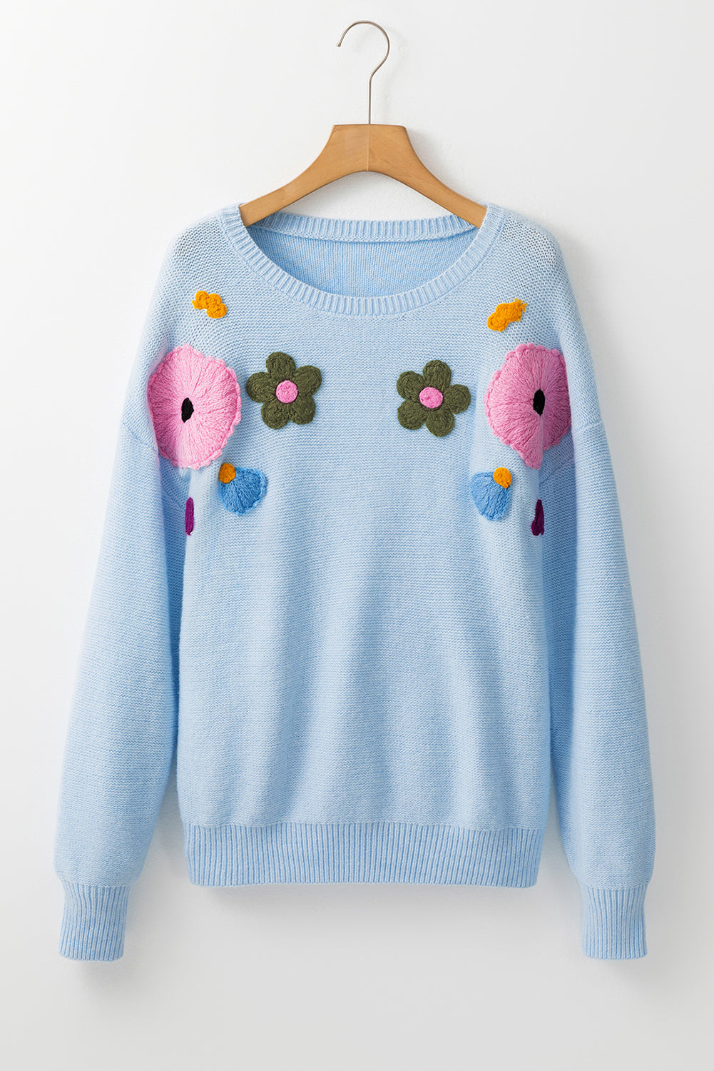 Light blue knitted sweater with ribbed edges and floral pattern