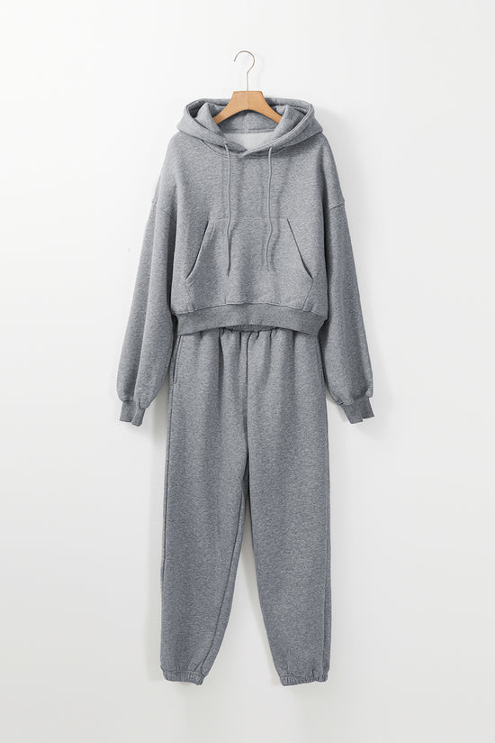 Set of plain gray sports clothes with hooded sweatshirt and jogging pants with falling shoulders