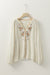 Beige loose shirt with puffy textured sleeves embroidered with flowers