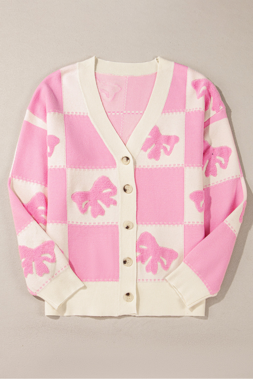 Cardigan boutonné à col en V et épaules tombantes avec motif à carreaux et nœud papillon rose