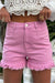 Mid-rise pink denim shorts with frayed edges