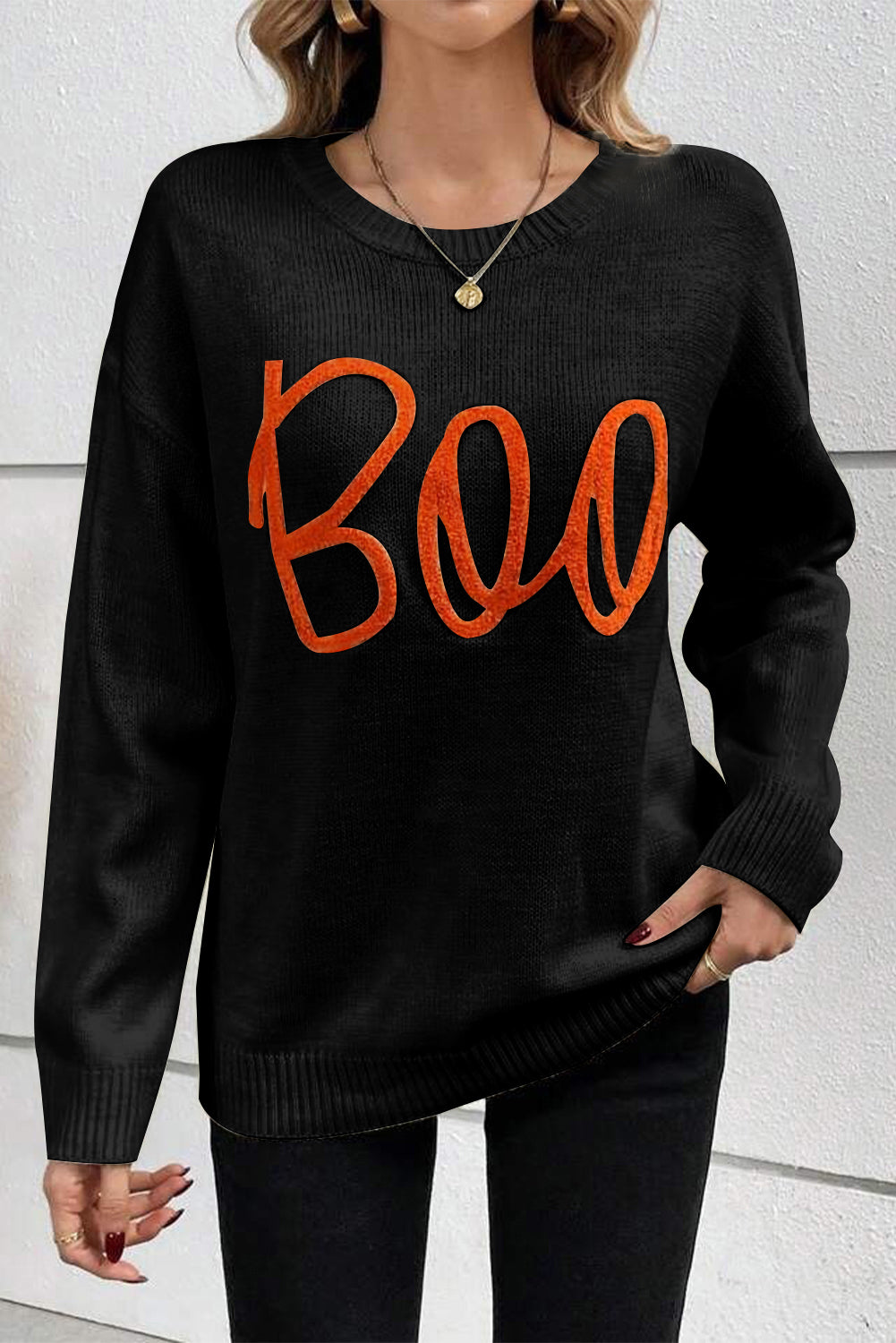 Black sweater with drooping shoulders and ribbed edges with Boo knitted pattern