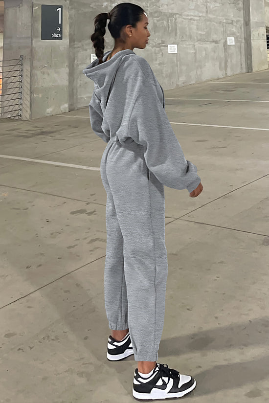 Set of plain gray sports clothes with hooded sweatshirt and jogging pants with falling shoulders