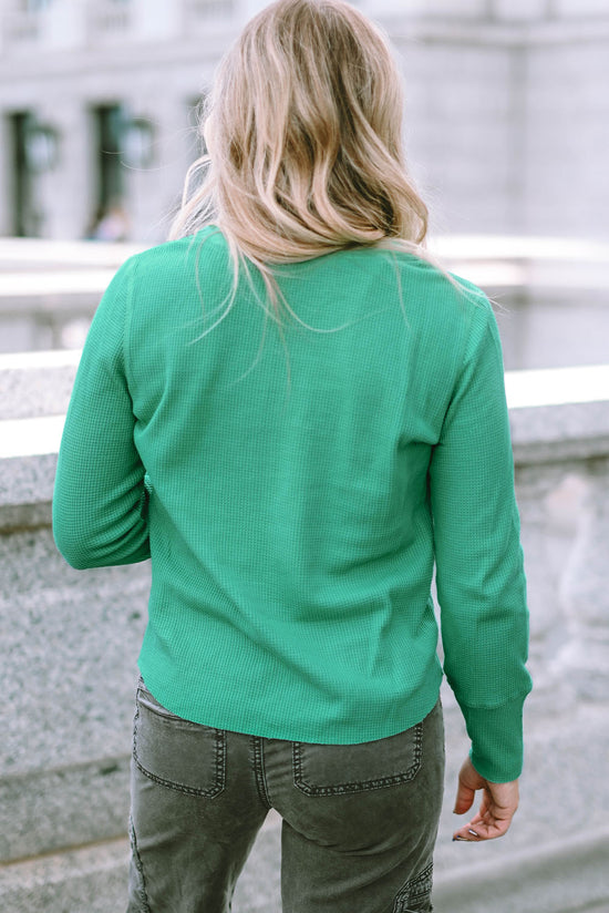 Alto Henley en tejido verde en relieve con un escote limitado