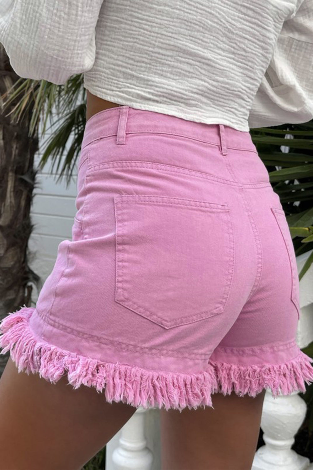 Mid-rise pink denim shorts with frayed edges