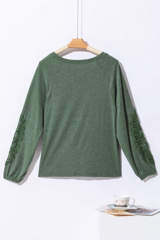 Green top with raglan sleeves and crochet lace patch