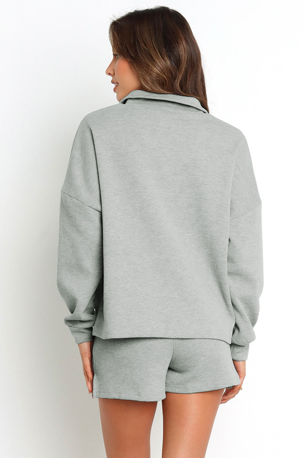 Sudadera gris con cremallera acanalada y pantalones cortos de cintura alta