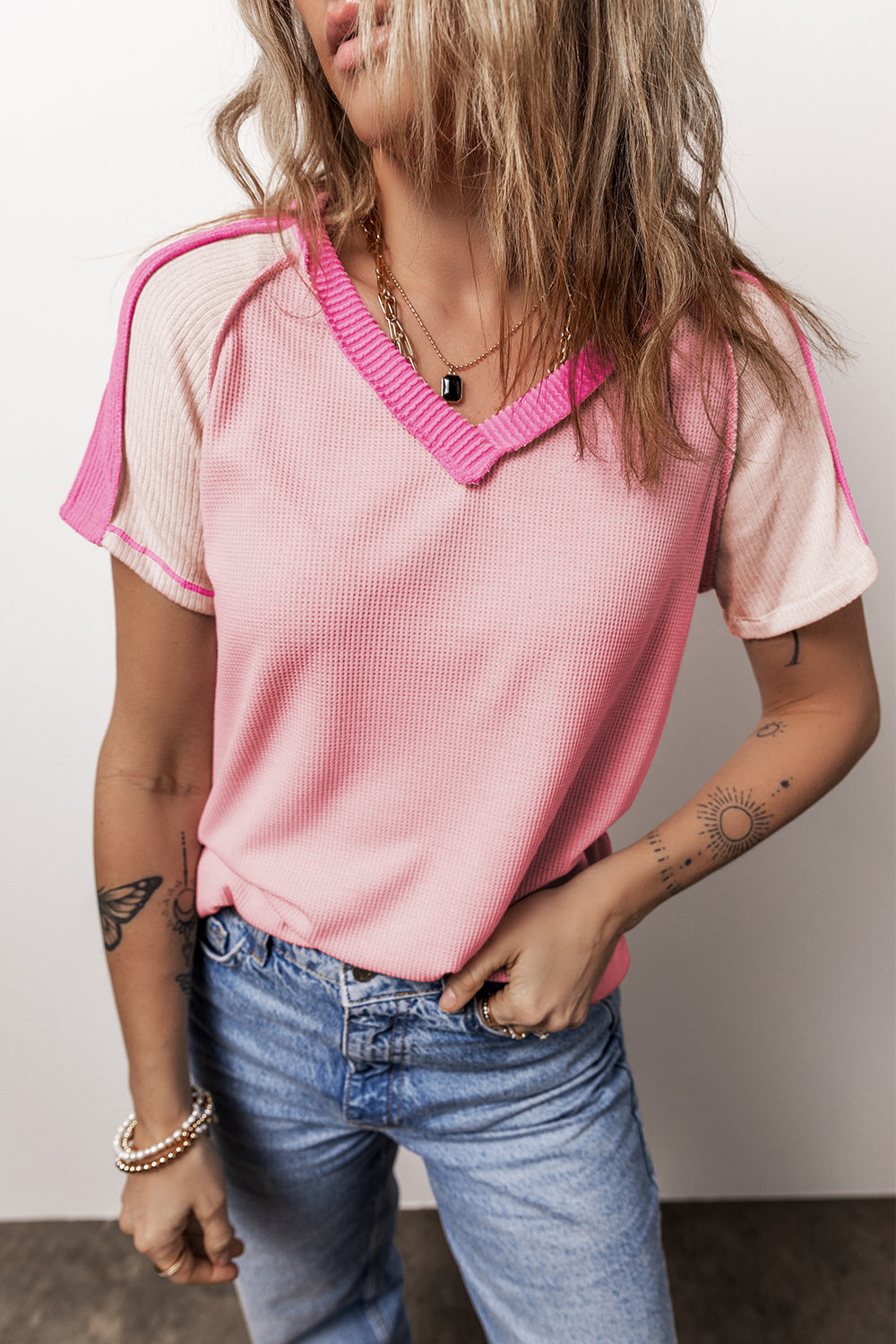 Camiseta rosa con cuello en V y costuras expuestas