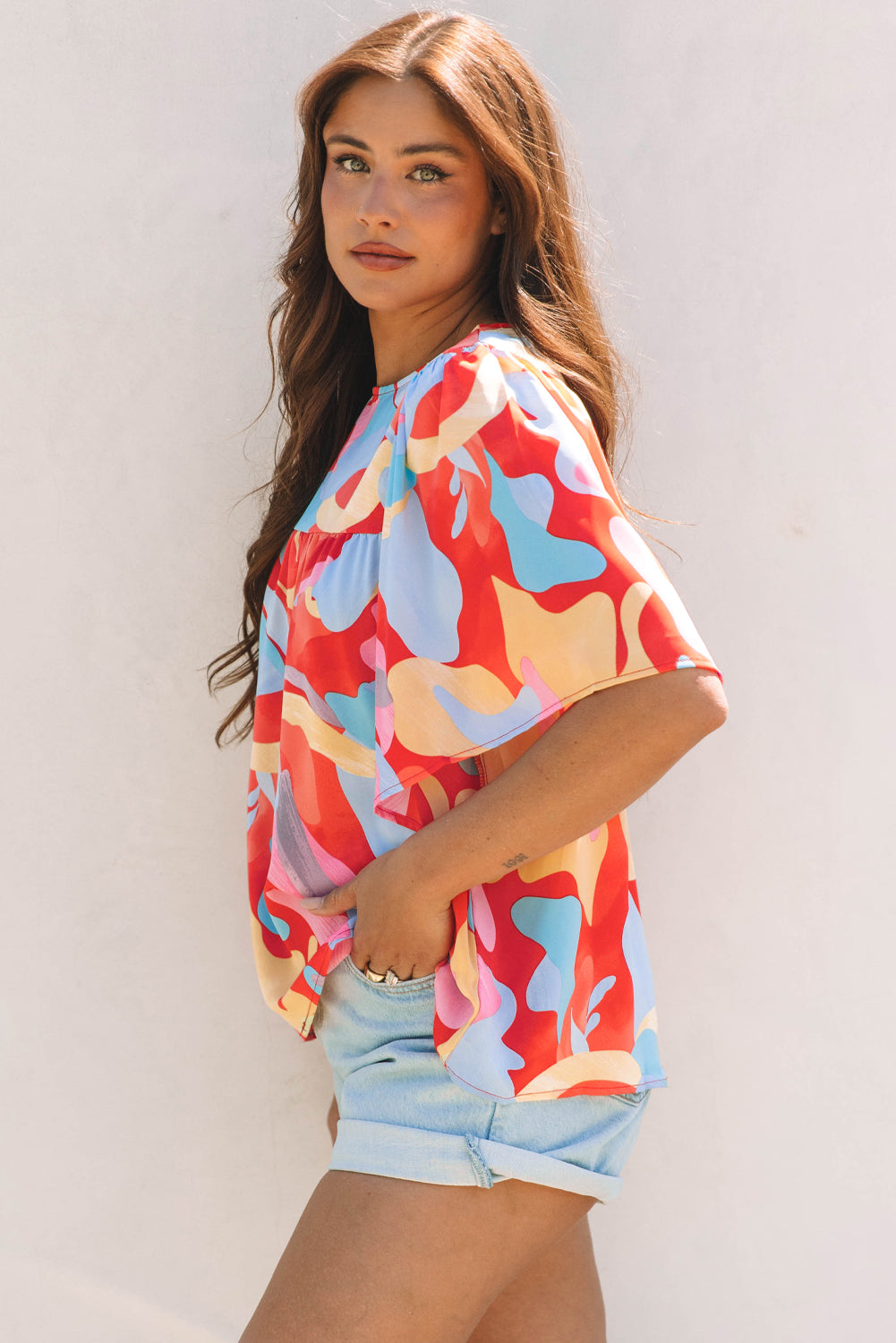 Blusa multicolor con cuello y mangas anchas con un patrón abstracto