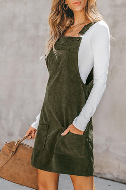 Sleeveless velvet overall dress with vineyard green pockets before